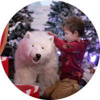 child playing with soft toy polar bear in Santa's Grotto.